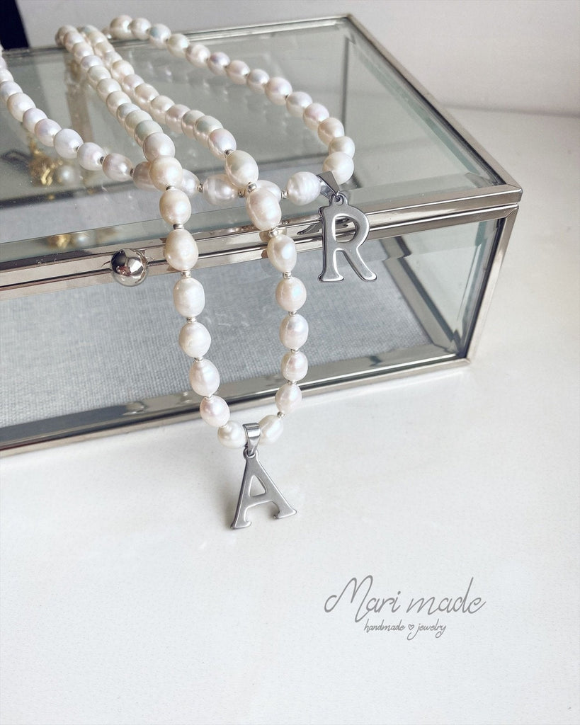 White pearl necklace with grey letter